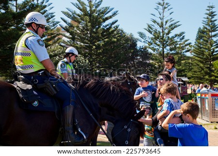COOGEE,AUSTRALIA - SEPTEMBER 28,2014: Mounted police meet the public at a beach soccer tournament between police and international students.