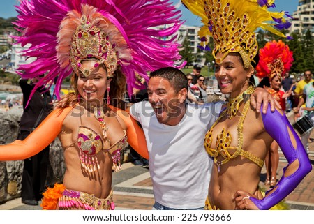 COOGEE,AUSTRALIA - SEPTEMBER 28,2014: A local man meets Brazilian dancers at a beach soccer tournament between police and international students.
