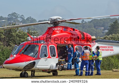 PALM BEACH,AUSTRALIA - JANUARY 1,2014: An air ambulance prepares to take a young man to hospital. He had to be resuscitated after jumping off a rock into the ocean.