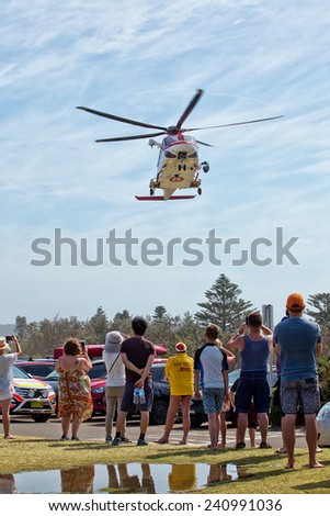 PALM BEACH,AUSTRALIA - JANUARY 1,2015: An air ambulance takes a young man to hospital, watched by a lifesaver. The man had to be resuscitated after jumping off a rock into the ocean.