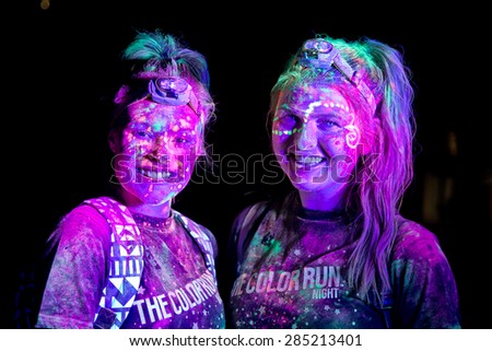 SYDNEY,AUSTRALIA - JUNE 6,2015: Women in the Color Run Night 5K fun run. Runners encounter bubble blowers, coloured powder and UV light, joining a dance party at the finish.