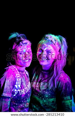 SYDNEY,AUSTRALIA - JUNE 6,2015: Women in the Color Run Night 5K fun run. Runners encounter bubble blowers, coloured powder and UV light, joining a dance party at the finish.