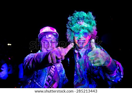 SYDNEY,AUSTRALIA - JUNE 6,2015: Men in the Color Run Night 5K fun run. Runners encounter bubble blowers, coloured powder and UV light, joining a dance party at the finish.