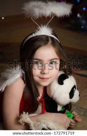 Young girl with blue eyes smiling. Halo on his head and head toy.