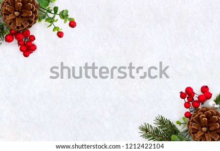 Christmas decoration. Frame of twigs christmas tree, brown natural pine cones and red berries on snow with space for text. Top view, flat lay