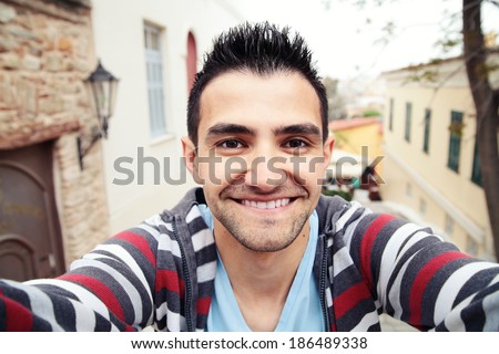 Man taking self portrait in the europe streets.Athens,Gree ce.Smiling young man.Travel selfie.