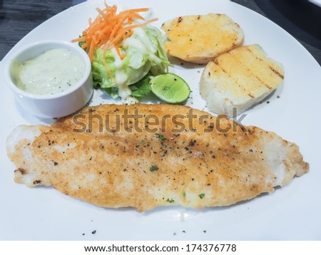 The seasoning fillet fish steak with salad and garlic bread