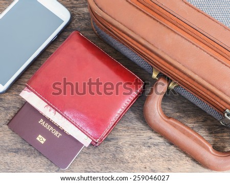 Mobile phone, passport and briefcase on wooden table for business traveling background