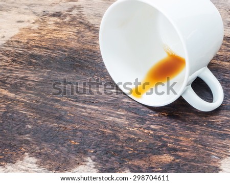 coffee spilled out from white cup on wooden background