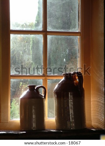 Sunlit jugs in pub window