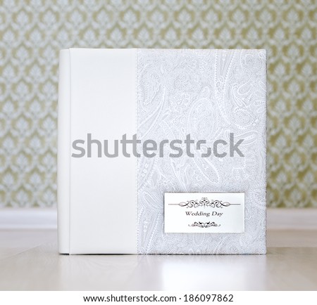 Wedding photo book with combined ivory leather cover and metal shield with title \