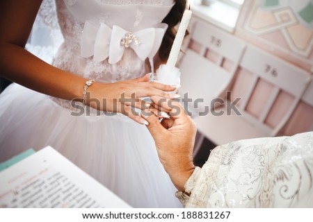Wedding ceremony in church. Priest puts a wedding ring on bride's finger