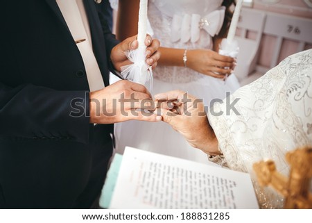 Wedding ceremony in church. Priest puts a wedding ring on groom\'s finger
