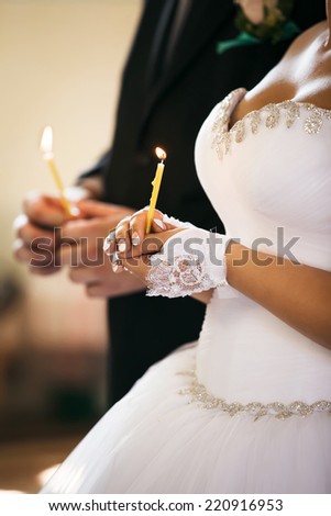 Bride hold a candle. Wedding ceremony in church.