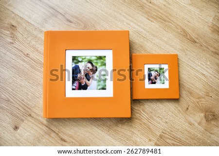 Wedding photo album and CD box with orange leather cover and passe-partout