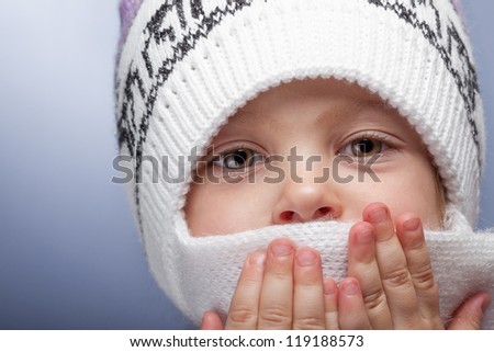 Little girl covering her face with scarf to keep warm
