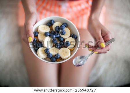 Healthy food. Girl with blueberry cereal breakfast and a spoon