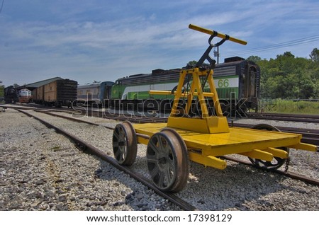 A railroad handtrolly awaits its driver at a rail yard.