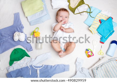 Baby on white background with clothing, toiletries, toys and health care accessories. Wish list or shopping overview for pregnancy and baby shower.