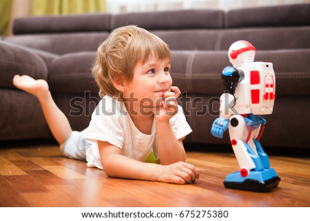 Little boy playing with robot toy at home