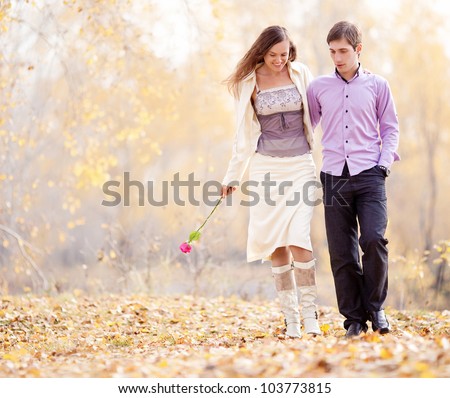 portrait of a happy loving couple walking  outdoor in the autumn park