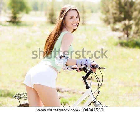 beautiful young woman  riding a bicycle on a warm summer day