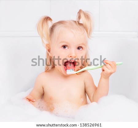 two year old girl taking a bath and brushing teeth