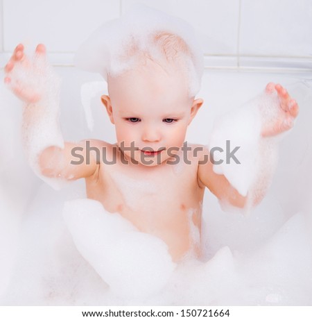 cute baby girl taking a bath with foam