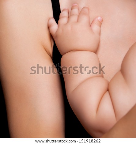 baby\'s hand on the chest of his mother, studio photo