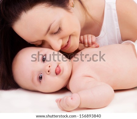 young beautiful mother and three months old baby in bed