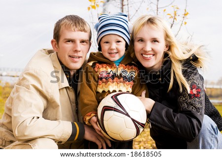 happy smiling family with a football ball outdoor