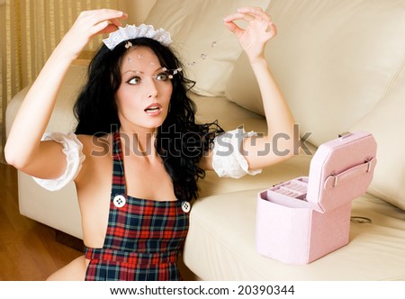 beautiful sexy surprised maid with the expensive jewelry in her hands