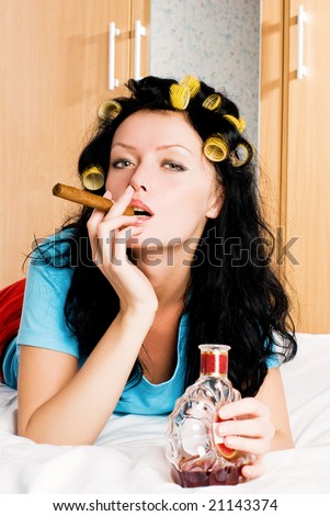 stock photo sexy housewife wearing hair curlers with a bottle of cognac 