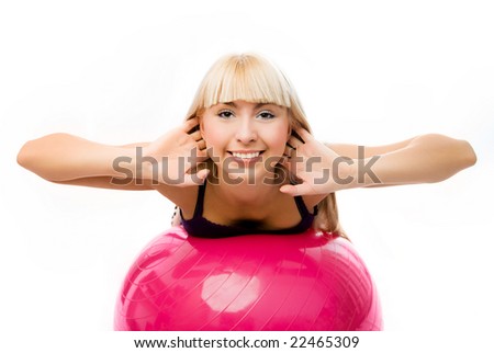 beautiful happy young blond woman works out on the bog pink fitness ball