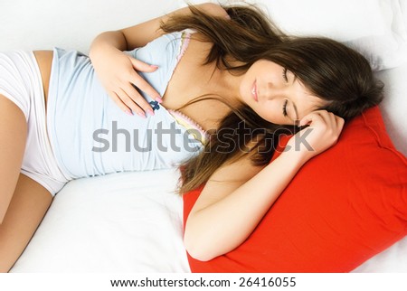 beautiful young brunette woman sleeping peacefully in her bed at home