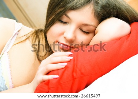 beautiful young brunette woman sleeping peacefully in her bed
