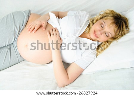 beautiful pregnant woman sleeping peacefully in her bed