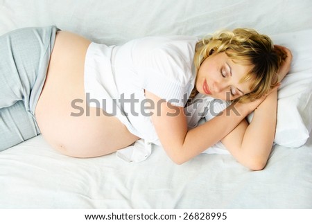 beautiful young pregnant woman sleeping peacefully in her bed at home