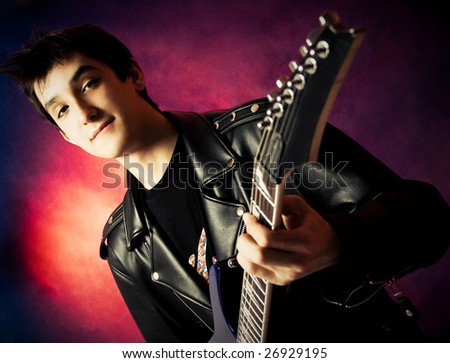 handsome young man wearing a leather jacket playing a guitar