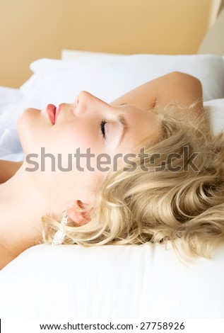 profile of a beautiful young blond woman sleeping peacefully in her bed at home