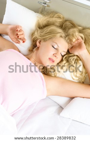 beautiful young woman sleeping peacefully in her bed at home