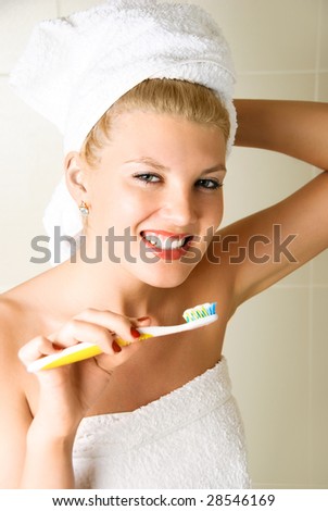happy young beautiful woman brushing her teeth in the bathroom