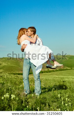 happy young loving couple kissing outdoor in summertime