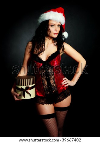 sexy young brunette woman wearing underwear and a Santa's hat with a Christmas present