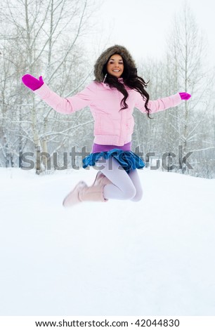 portrait of a happy young jumping girl in the winter park