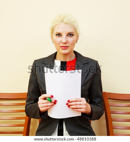 young attractive businesswoman sitting on the chair and writing