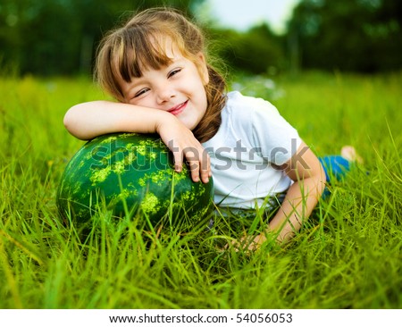cute little girl with a water-melon on the grass in summertime
