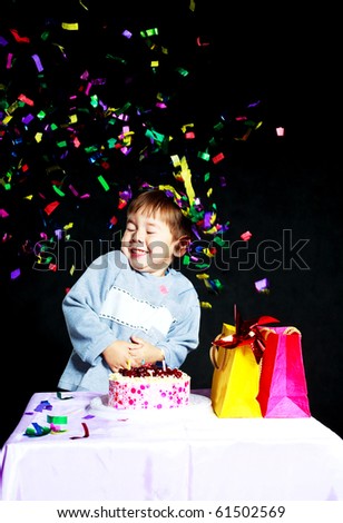 cute three year old baby celebrating his birthday and blowing off the candles on the cake