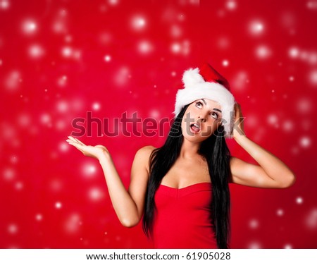 beautiful girl dressed as Santa surprised with snow falling on her