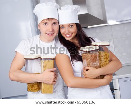 two happy young cooks in love in the kitchen